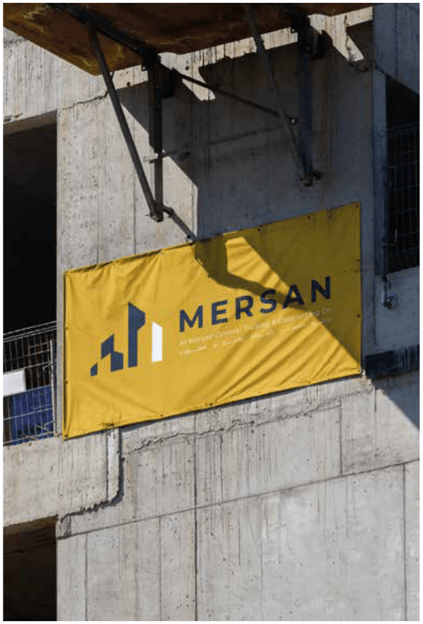 An ALMERSAN banner mounted on the wall of an unfinished concrete building at a construction site